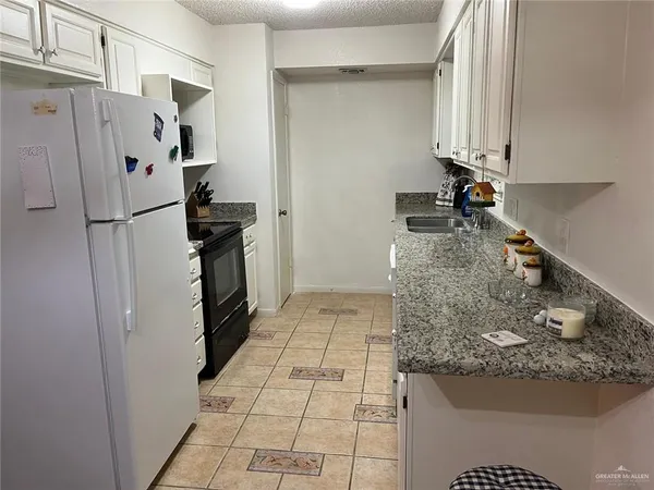 a kitchen with stainless steel appliances granite countertop a refrigerator and a stove