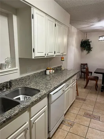 a kitchen with granite countertop a sink and a stove