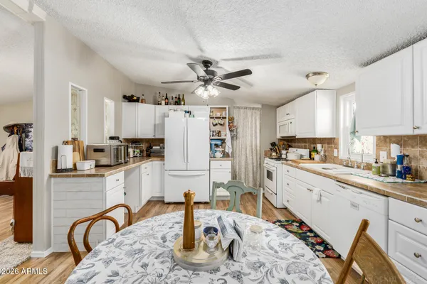a kitchen with granite countertop a refrigerator stove top oven and sink