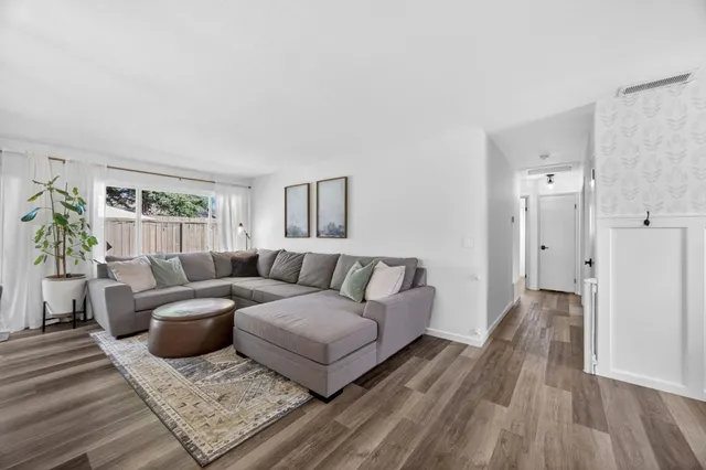 a view of a patio with table and chairs under an umbrella with large trees