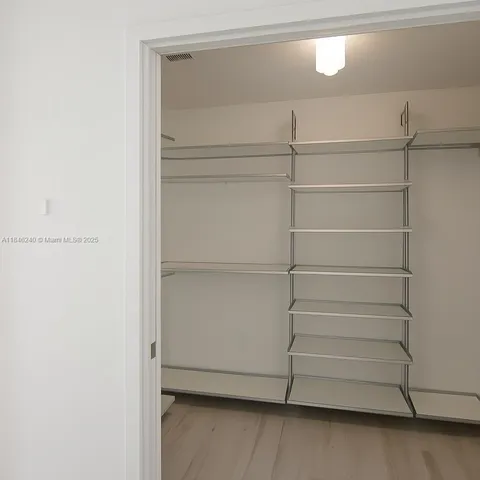 a view of walk in closet with empty racks