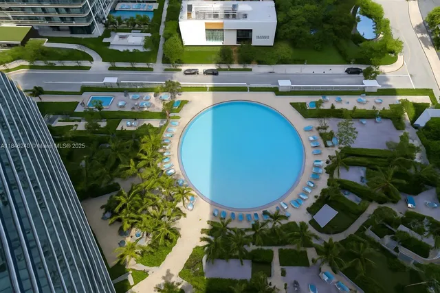 an aerial view of a swimming pool with outdoor seating