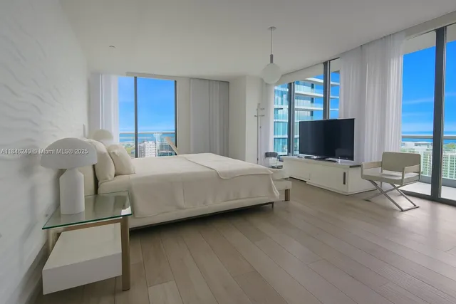 a bedroom with a bed and large flat screen tv