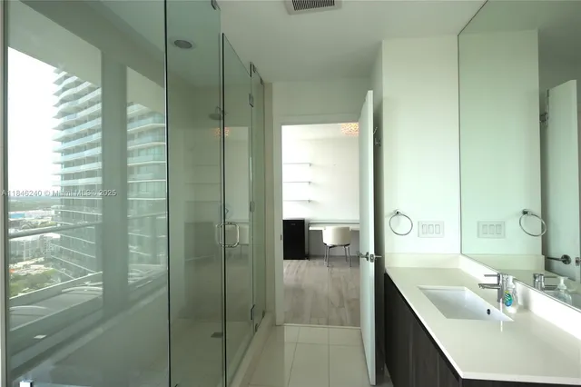 a bathroom with a shower sink and mirror