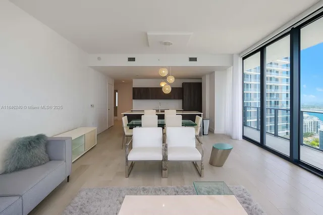 a living room with furniture a view of dining room and wooden floor
