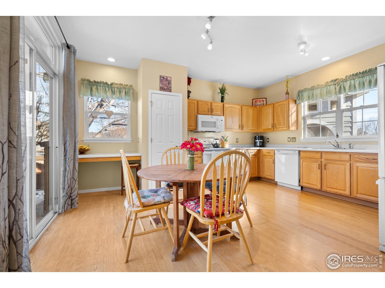 10351 Cook Way Thornton, CO 80229 - Photo 11 of 30 a dinning dining room filled with stainless steel appliances kitchen island granite countertop a dining table chairs and a refrigerator