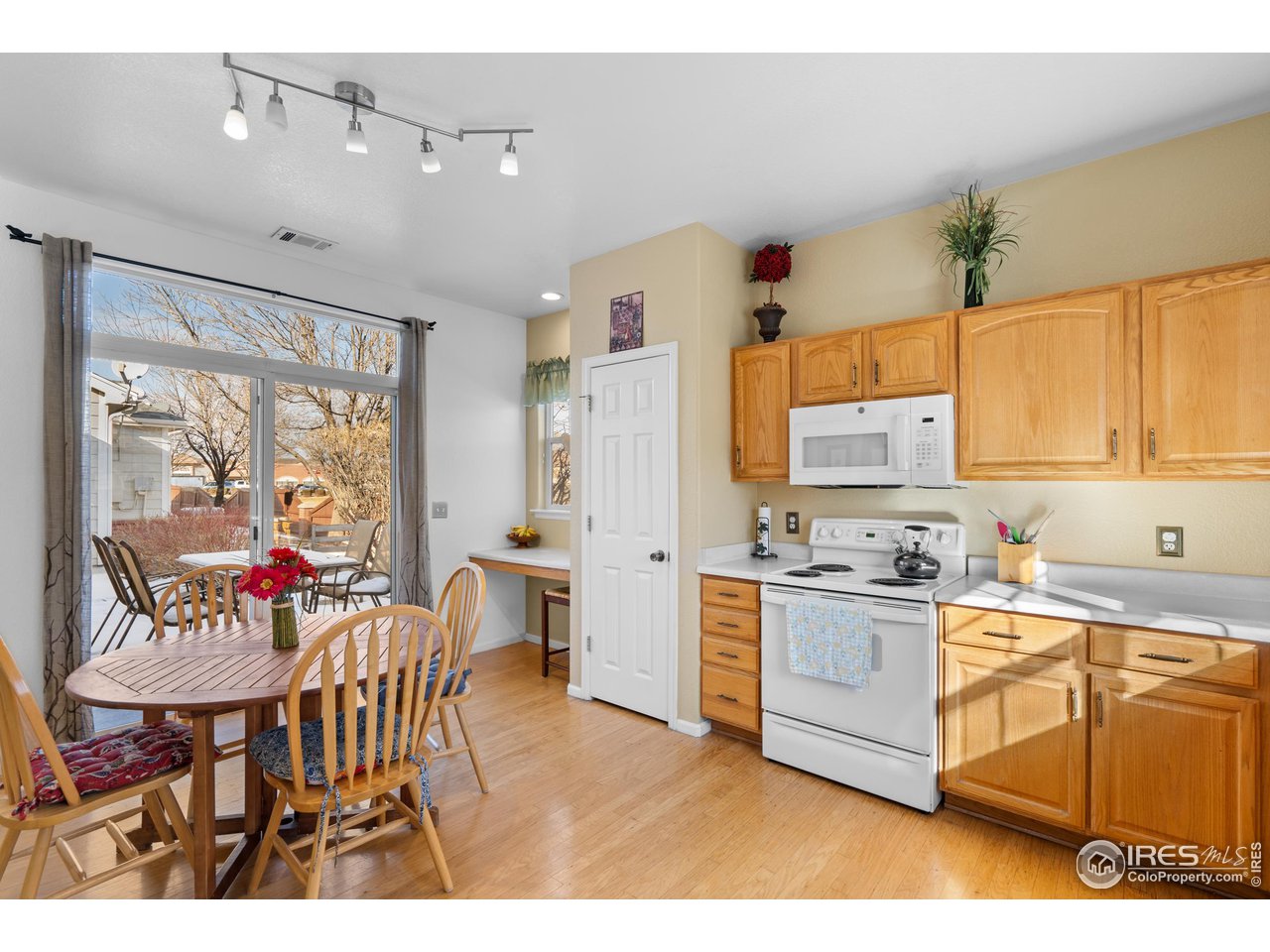 10351 Cook Way Thornton, CO 80229 - Photo 29 of 30 a open kitchen with stainless steel appliances kitchen island granite countertop a stove a refrigerator a dining table and chairs with wooden floor