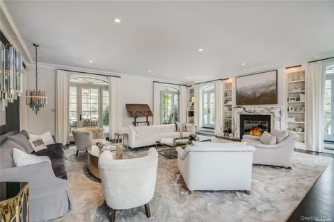 a living room with furniture a fireplace and a large window