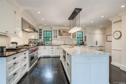 a large kitchen with stainless steel appliances granite countertop a lot of counter space and wooden floors