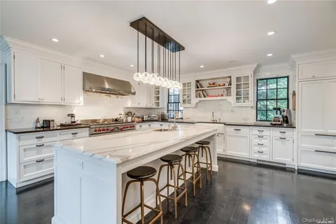 a kitchen with stainless steel appliances white cabinets sink and stove