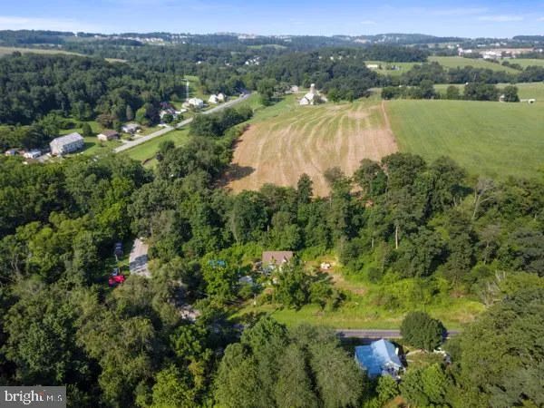 an aerial view of residential houses with outdoor space and trees