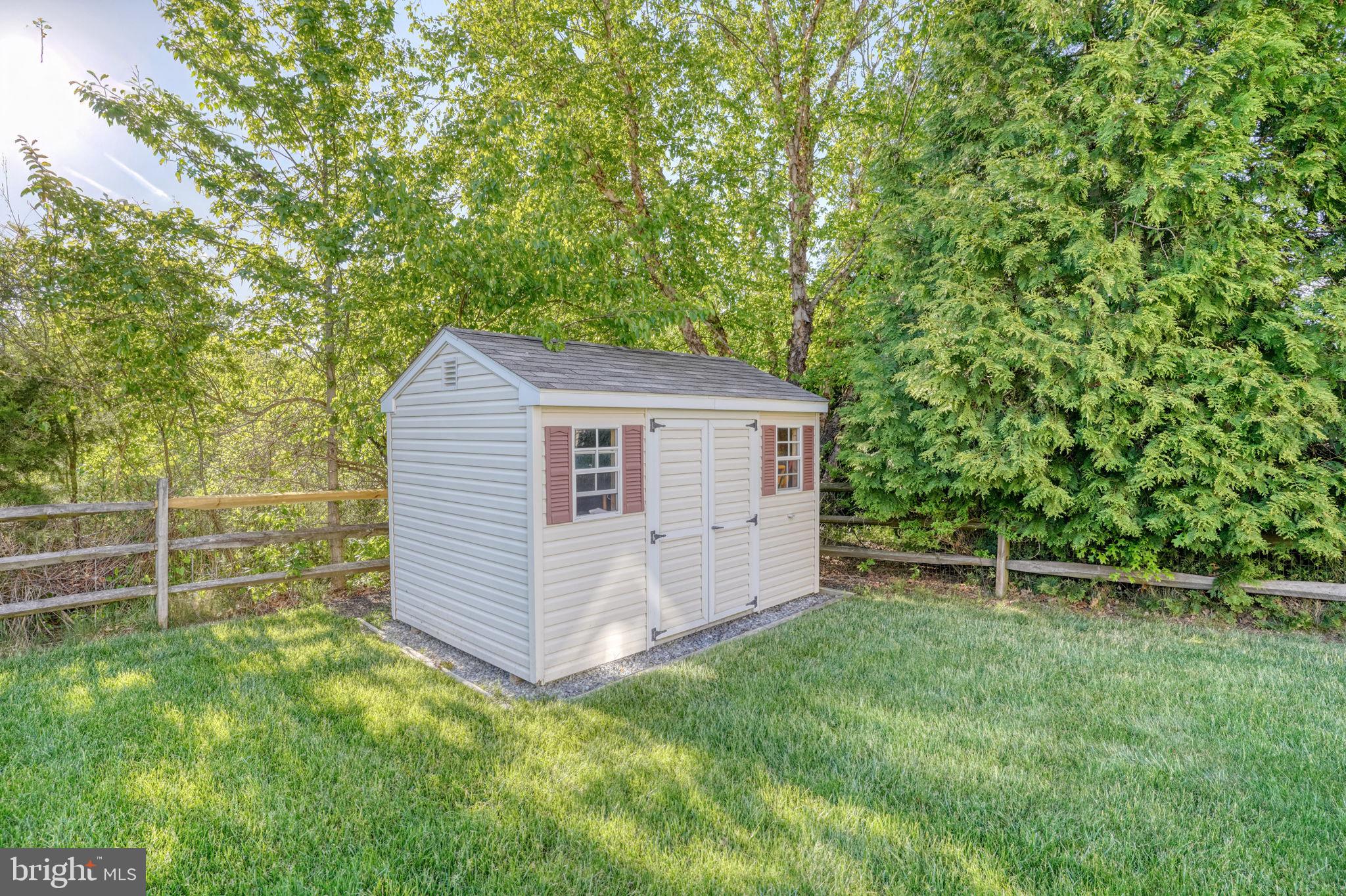 213 Loft Street Townsend, DE 19734 - Photo 17 of 76 Charming garden shed in lush greenery.