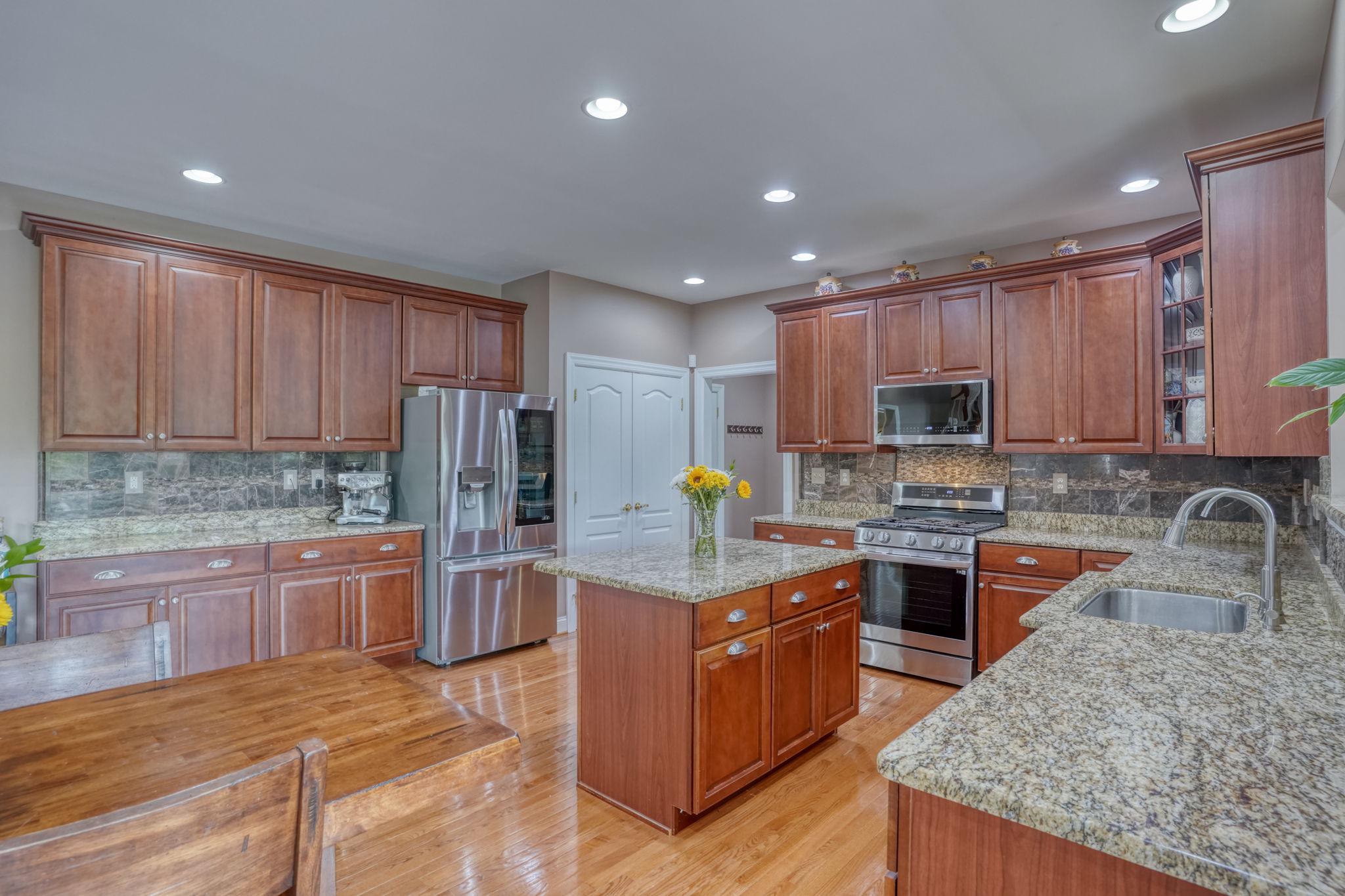 213 Loft Street Townsend, DE 19734 - Photo 36 of 76 a kitchen with stainless steel appliances granite countertop a stove top oven a sink dishwasher a refrigerator and cabinets with wooden floor
