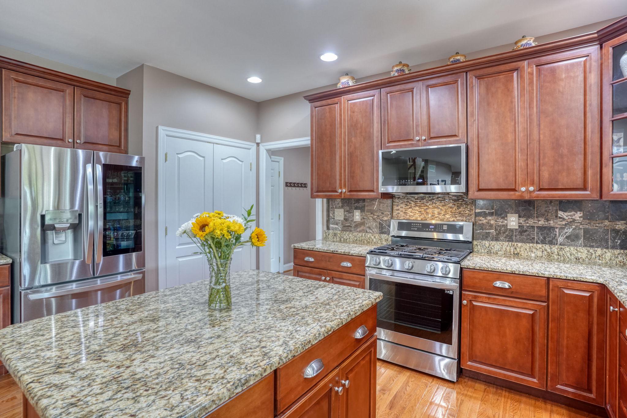 213 Loft Street Townsend, DE 19734 - Photo 40 of 76 a kitchen with stainless steel appliances granite countertop a stove a sink and a microwave