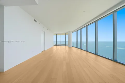a big room with a bed and wooden floor