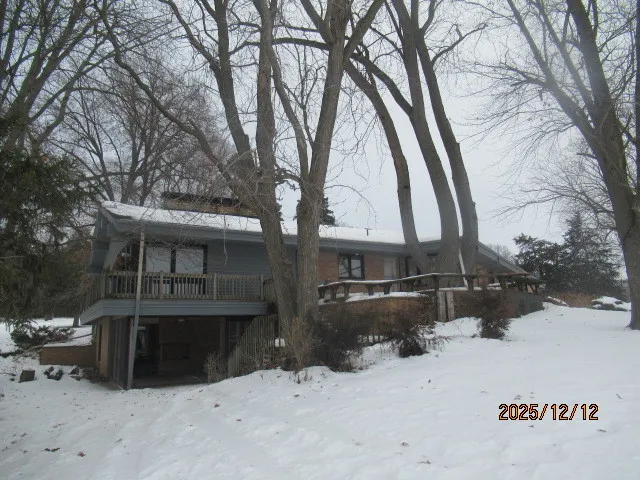 a front view of house with yard covered in snow