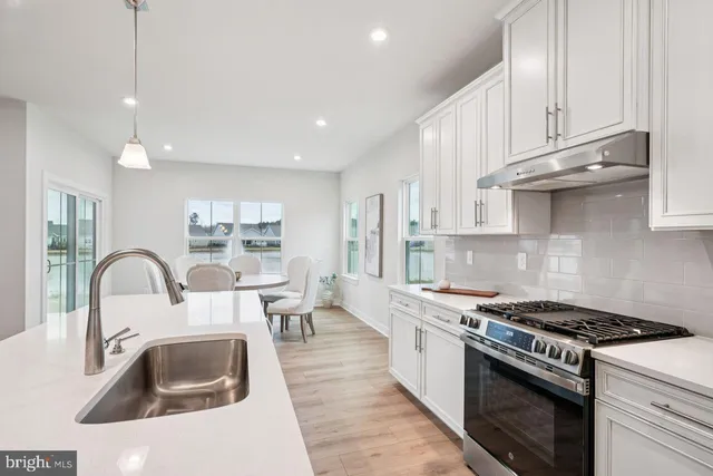 a kitchen with sink a stove and cabinets