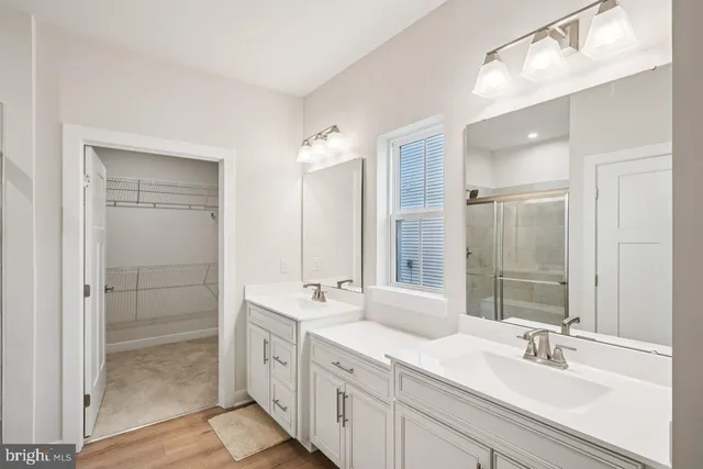 a bathroom with double vanity sinks and a mirror