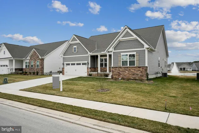 a view of a house next to a yard with big trees