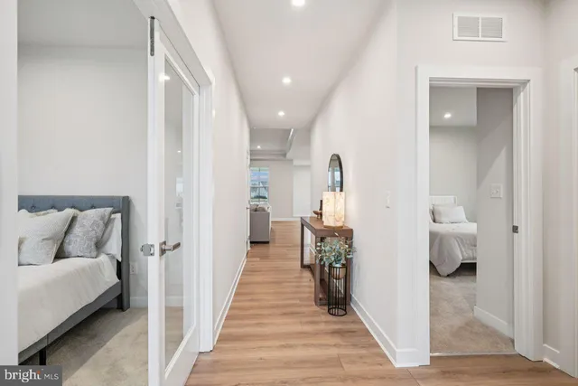 a hallway with white cabinets and wooden floor