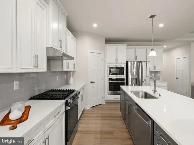 a kitchen with stainless steel appliances kitchen island a sink stove and refrigerator