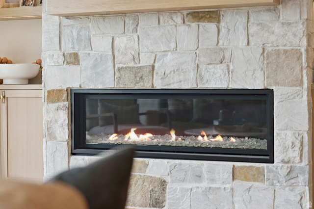 1400 Weber Wild Road Oakley, UT 84055 - Photo 20 of 55 Stone fireplace featuring a linear gas insert with a black frame and decorative glass media