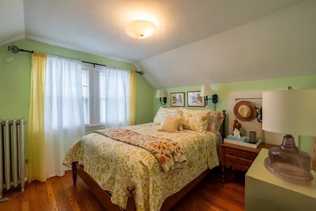 a bedroom with a bed and a dresser next to a window