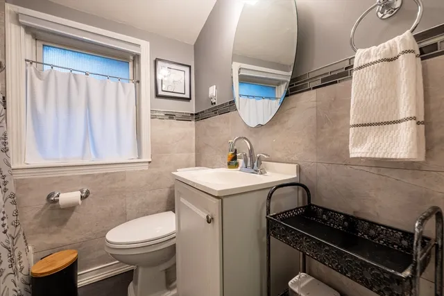 a bathroom with a granite countertop toilet sink and mirror