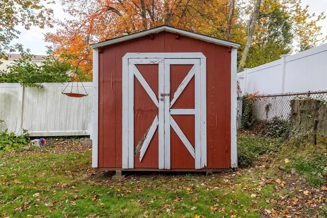a view of backyard of house with wooden fence