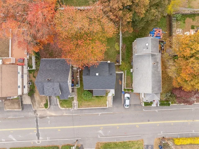 an aerial view of residential houses with outdoor space and parking