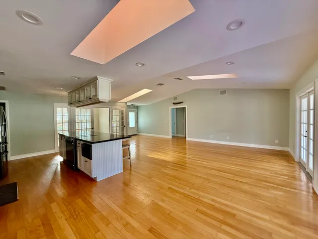 a big room with wooden floor and pool table