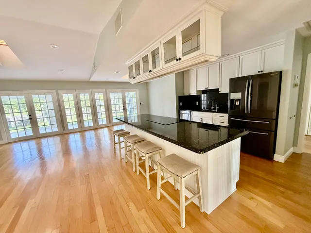 a kitchen with stainless steel appliances granite countertop a refrigerator a stove and a wooden floors