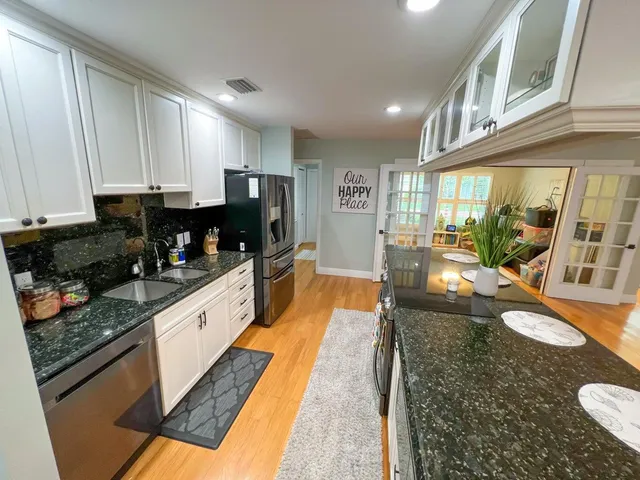 a large kitchen with stainless steel appliances granite countertop a lot of counter space and a window