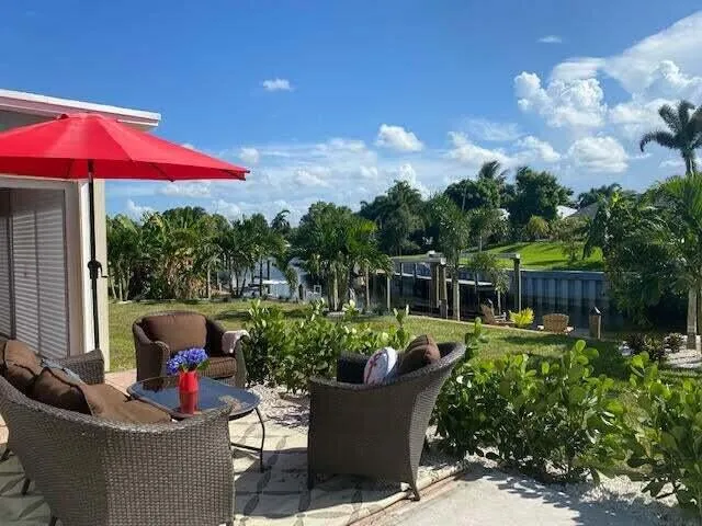 a view of a house with backyard sitting area and furniture