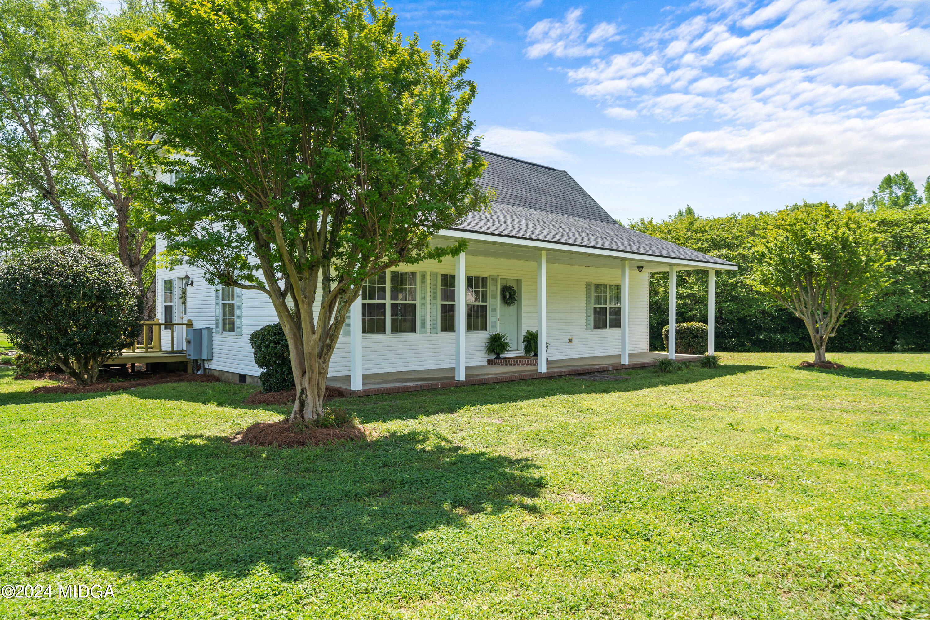 a view of a house with a yard and tree