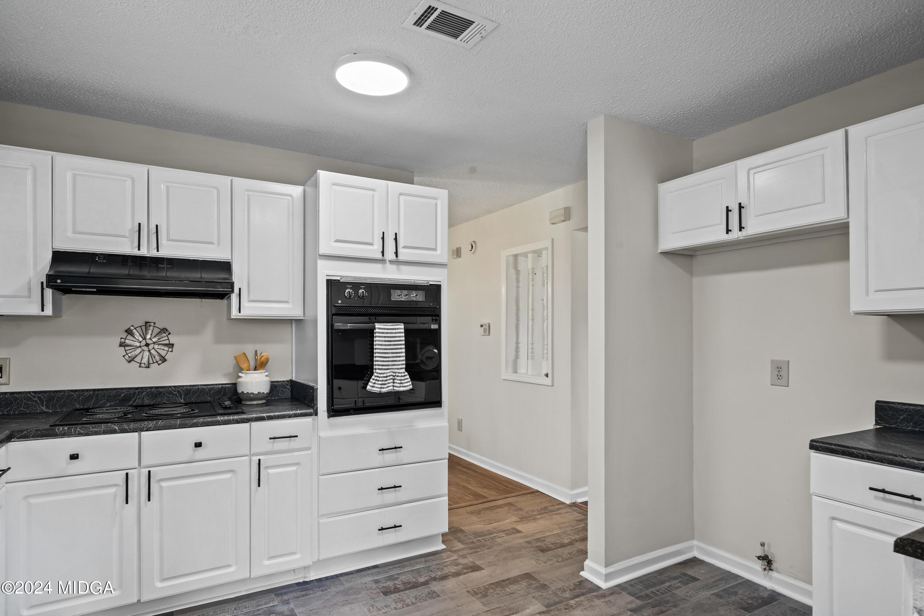 246 Langston Road Perry, GA 31069 - Photo 16 of 37 a kitchen with granite countertop white cabinets stainless steel appliances and sink