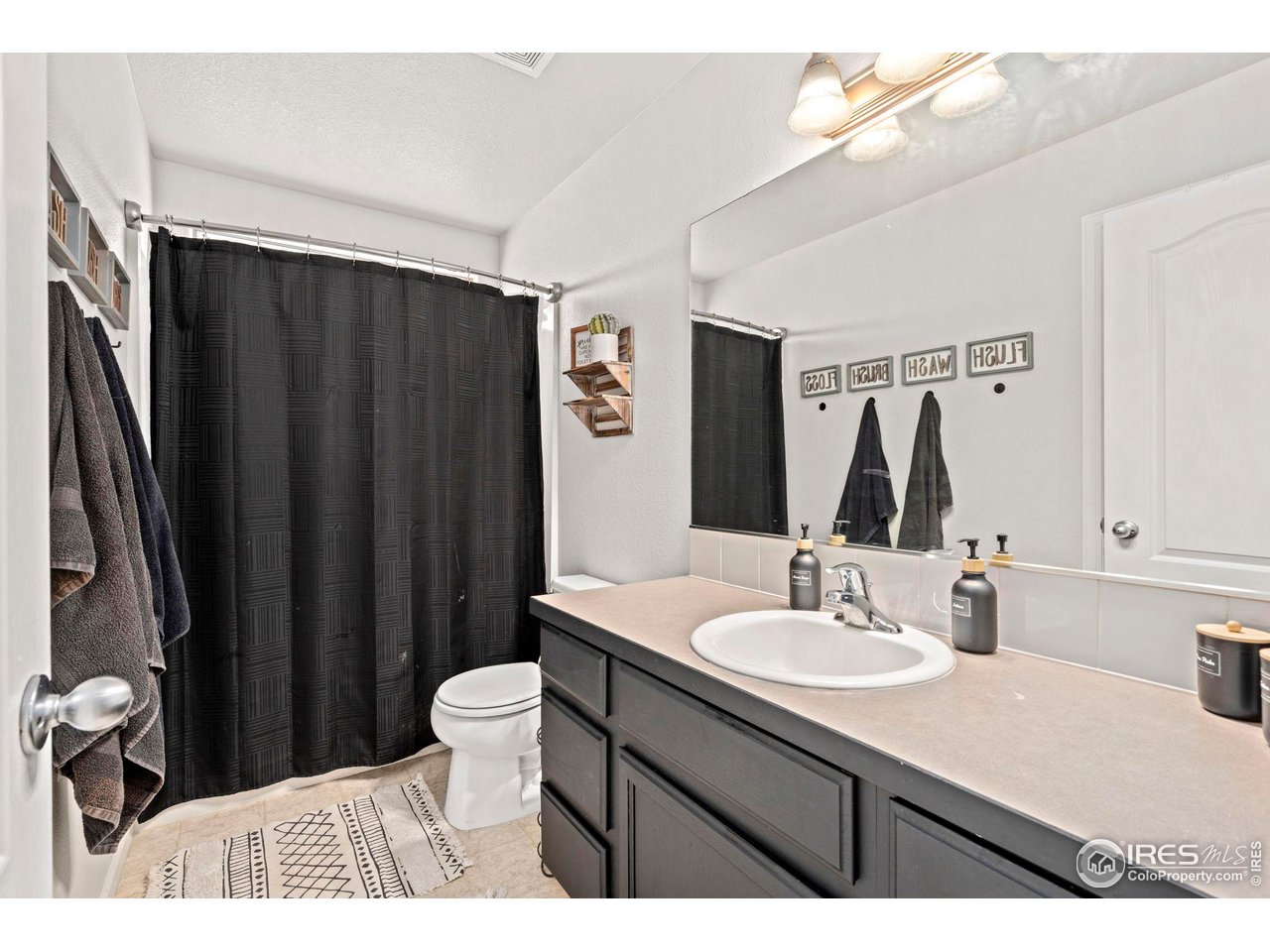 3224 Barbera Street Evans, CO 80634 - Photo 12 of 20 a bathroom with a sink vanity mirror and toilet