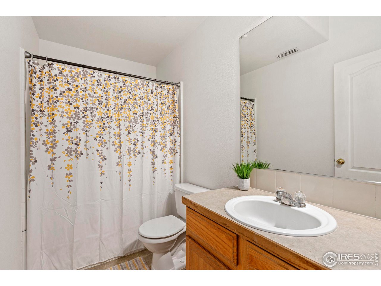3224 Barbera Street Evans, CO 80634 - Photo 15 of 20 a bathroom with a granite countertop sink and a mirror with toilet