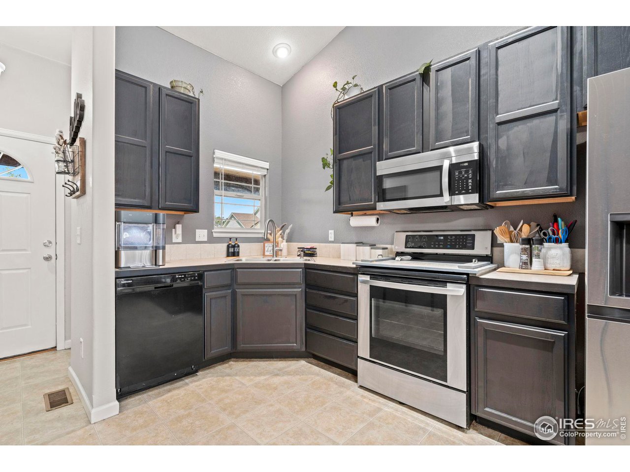 3224 Barbera Street Evans, CO 80634 - Photo 3 of 20 a kitchen with stainless steel appliances a stove sink microwave and cabinets