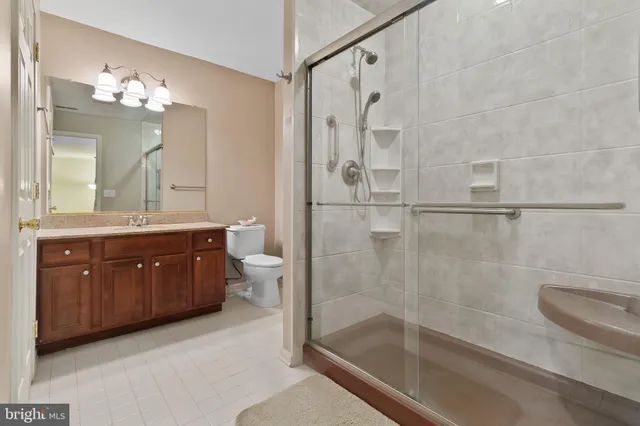 a bathroom with a granite countertop sink a toilet and shower