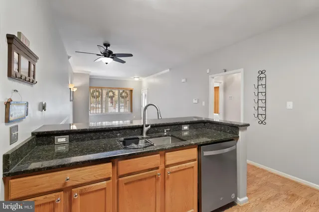 a kitchen with granite countertop a sink a counter top space and cabinets