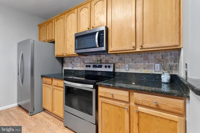 a kitchen with stainless steel appliances granite countertop a sink stove and microwave