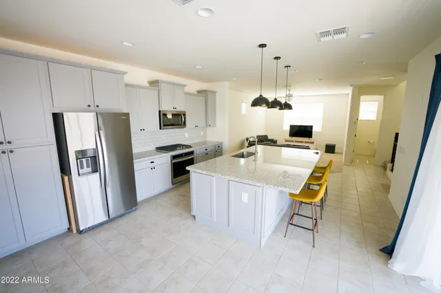 a kitchen that has a lot of counter space and stainless steel appliances