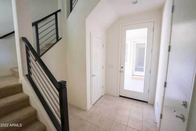 a view of a hallway with entryway and stairs