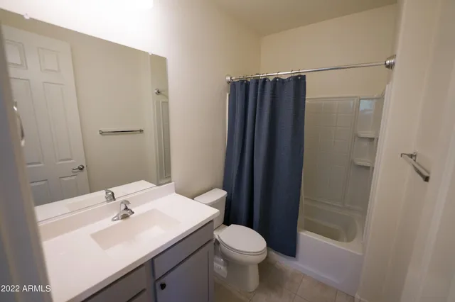 a bathroom with a sink a toilet a mirror and shower