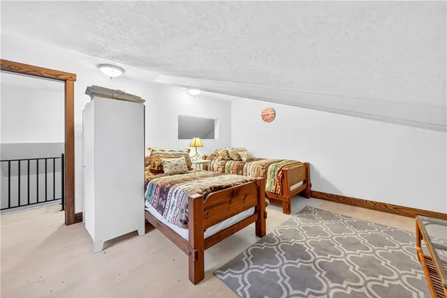 a bedroom with a bed and a lamp on dresser