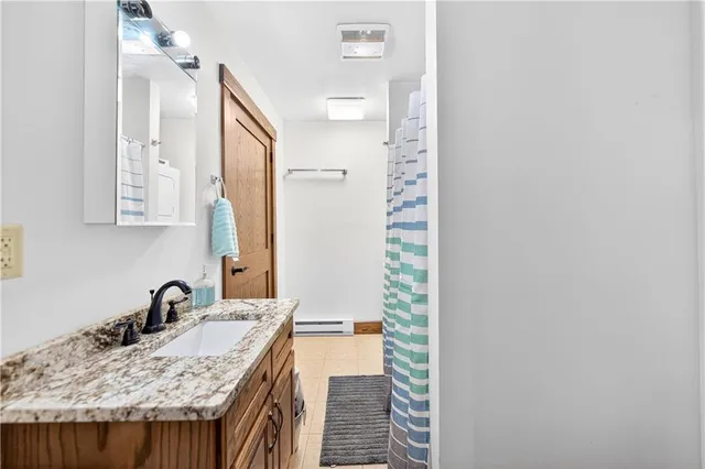 a bathroom with a granite countertop sink and a mirror