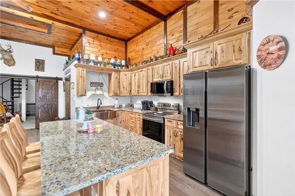 a kitchen with stainless steel appliances granite countertop a sink a stove and a refrigerator
