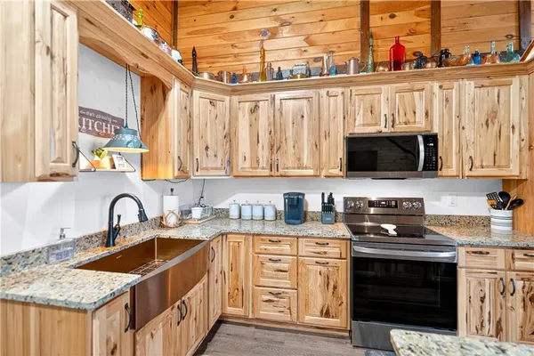 a kitchen with stainless steel appliances granite countertop a stove a sink and a microwave