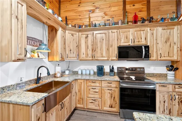 a kitchen with stainless steel appliances granite countertop a stove a sink and a microwave